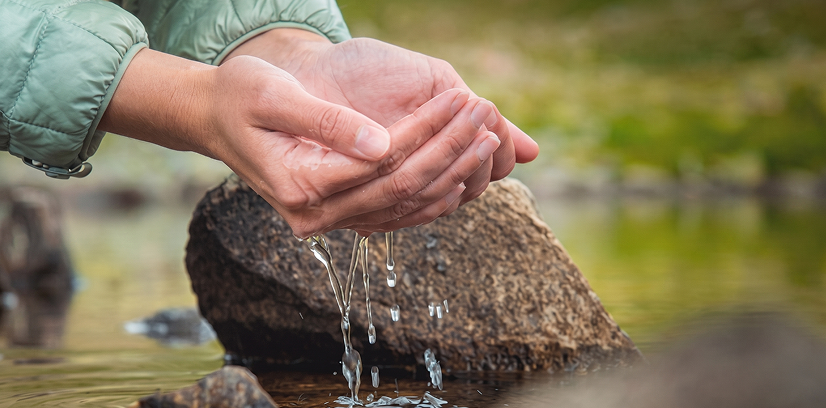 Manos recogiendo agua cristalina